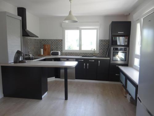 a kitchen with black cabinets and a sink and a window at Labassere in Labassère