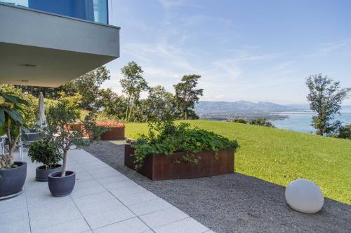 a patio with plants and a view of the water at Seeblick Appartements Henle in Bregenz