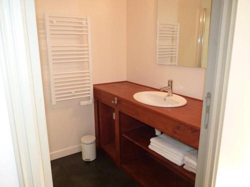a bathroom with a sink and a mirror at De l'Autre Côté in Garlin