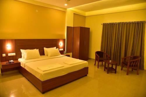una camera con letto, tavolo e sedie di Hotel Citywalk Residency a Mangalore