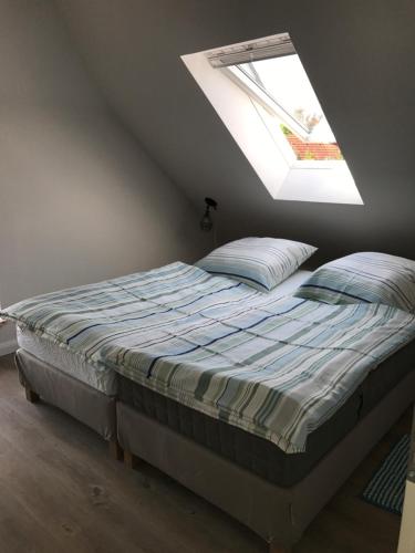 a bed in a room with a window at Hotel & Ferienunterkünfte Hus Seeblick in Fehmarn
