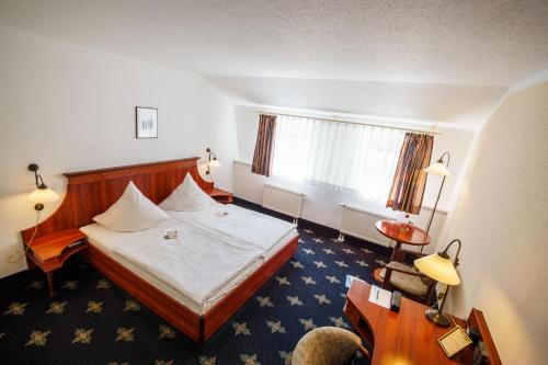 a hotel room with a bed and a window at Hotel Wilder Mann Annaberg-Buchholz in Annaberg-Buchholz