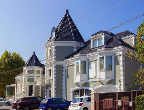 a large house with turrets on a street at Castello Boutique Hotel in Čačak