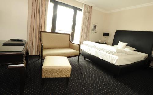 a bedroom with a bed and a desk and a chair at Hotel & Restaurant Schönau in Peine
