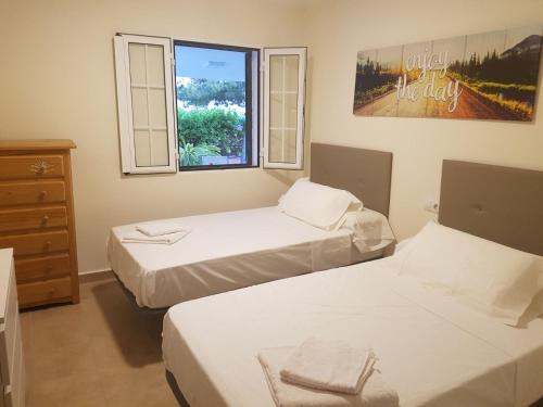 two beds in a room with a window at Chalet Bacarot in Alicante