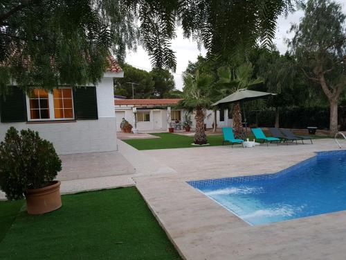 a backyard with a swimming pool and a house at Chalet Bacarot in Alicante