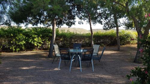 a table and chairs sitting under a group of trees at Chalet Bacarot in Alicante