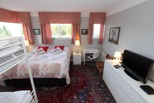 a bedroom with a bed and a flat screen tv at The Viking Country Club in Hjalteyri