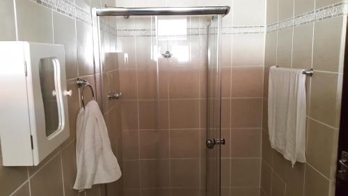 W łazience znajduje się prysznic ze szklanymi drzwiami. w obiekcie Third Rock Guesthouse w mieście Ventersburg