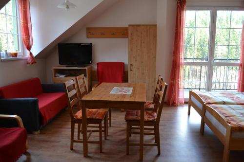 a living room with a table and a couch at Orbit Karlov pod Pradědem in Malá Morávka