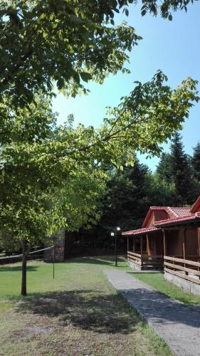 a building in a park with a tree at Livadaki Village in Megáli Kápsi