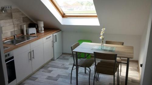 a kitchen with a table and chairs and a window at PENNY Ferienwohnung in Velpke