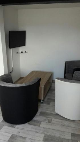 a living room with two chairs and a table at PENNY Ferienwohnung in Velpke