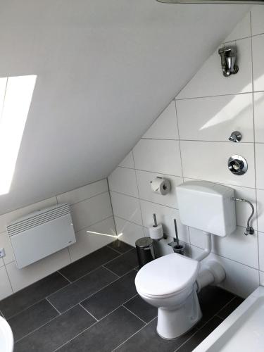a white bathroom with a toilet and a sink at PENNY Ferienwohnung in Velpke