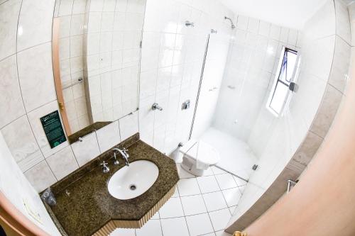 a bathroom with a sink and a shower at Hotel Center in Xanxerê