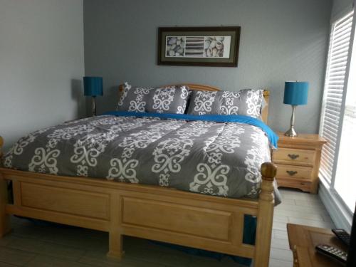 a bedroom with a bed with a gray and white comforter at 1+1 Large condo Sarasota in Sarasota