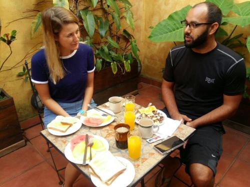 a man and a woman sitting at a table with food at Costa Rica Guesthouse in San José