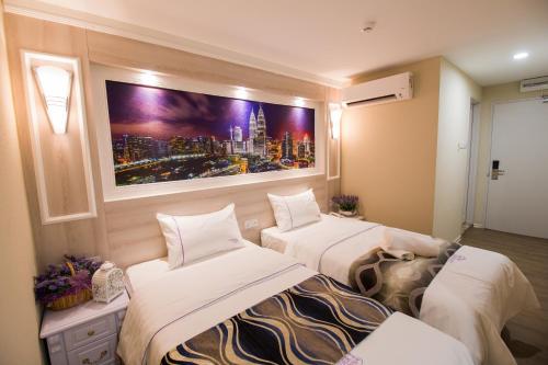 a room with two beds and a painting on the wall at Lavender Inn USJ in Subang Jaya