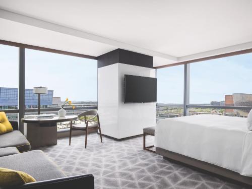 a bedroom with a bed and a desk and a tv at Cordis Shanghai Hongqiao (Langham Hospitality Group) in Shanghai