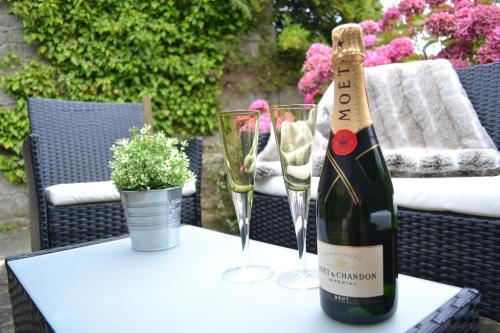 a bottle of champagne and two glasses on a table at Riverside Cottage in Wetherby