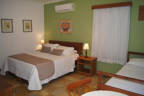 a hotel room with two beds and a window at Pousada Paisagem in Paraty