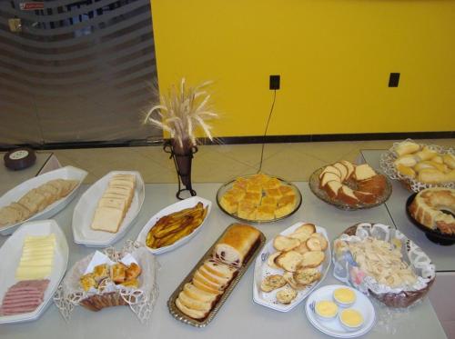 een tafel vol met verschillende soorten brood en gebak bij Pousada Cardoso in Ipiaú