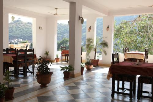 a dining room with tables and chairs and large windows at Haveli Katkoun in Būndi
