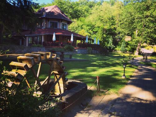 a house with a wooden fence in a yard at Hotel Síkfőkút in Noszvaj