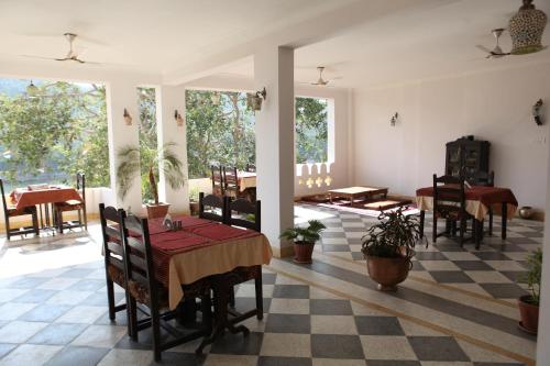 un comedor con mesas, sillas y ventanas en Haveli Katkoun, en Bundi