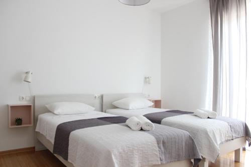 twee bedden in een witte kamer met handdoeken erop bij Apartment Luce in Trogir