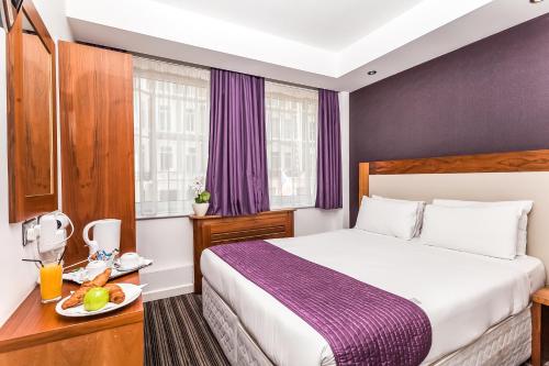 מיטה או מיטות בחדר ב-Ambassadors Hotel