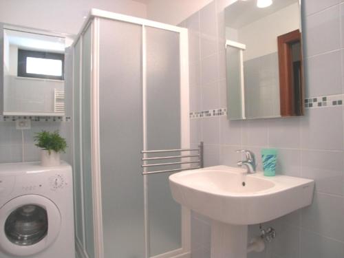 a bathroom with a sink and a washing machine at Villa Olimpia in Grado