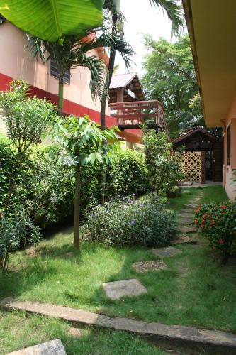 a garden with flowers and a stairway to a house at Hotel Aurore Lomé in Lomé