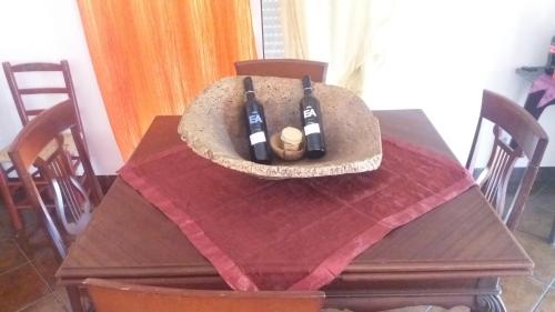 a wooden table with two bottles of wine on it at Évora Romana Alojamentos T3 Cartuxa in Évora