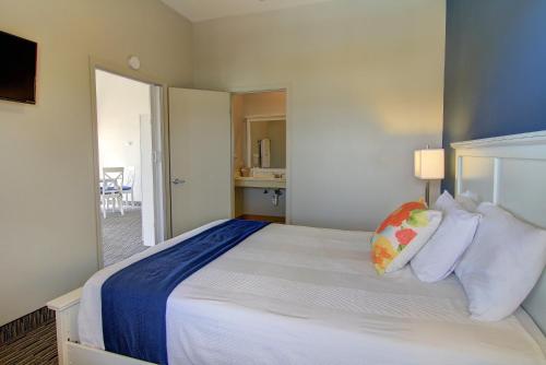 a bedroom with a large white bed with pillows at Alister Square Inn in Port Aransas