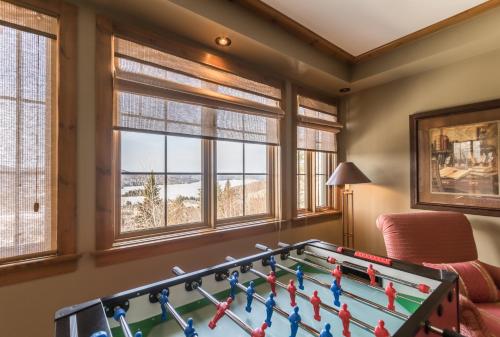 een pooltafel in een kamer met ramen bij Tremblant Prestige - Equinoxe 140-1 in Mont-Tremblant