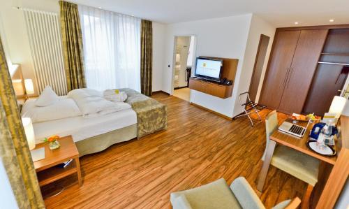 a hotel room with a bed and a television at Hotel Klostergarten in Kevelaer