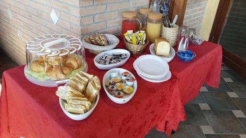 Una mesa roja con pan y otros alimentos sobre ella. en La Locanda dei Cavalieri Affittacamere, en Lugagnano Val dʼArda