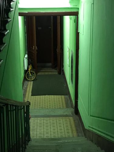 an empty hallway with green walls and a room with a bike at Inn Na Finskom in Saint Petersburg