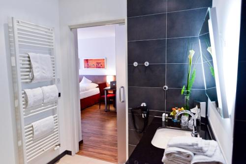 een kleine badkamer met een wastafel en een douche bij Hotel Klostergarten in Kevelaer