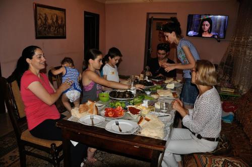 a group of people sitting around a table eating food at Karine B&B in Yeghegnadzor