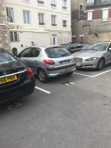 a group of cars parked in a parking lot at Hotel l'Avenue in Chantilly