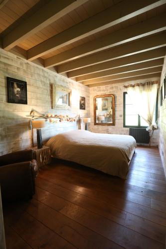 une chambre avec un grand lit et un parquet dans l'établissement Chalet Montagne, à Saint-Pastous