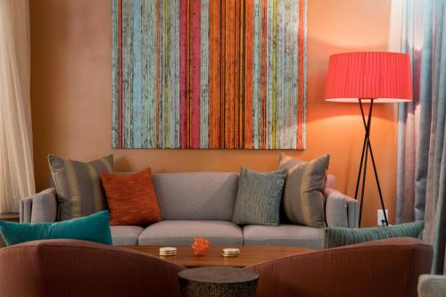 a living room with a couch with colorful pillows at Unscripted Durham, Part of JDV by Hyatt in Durham