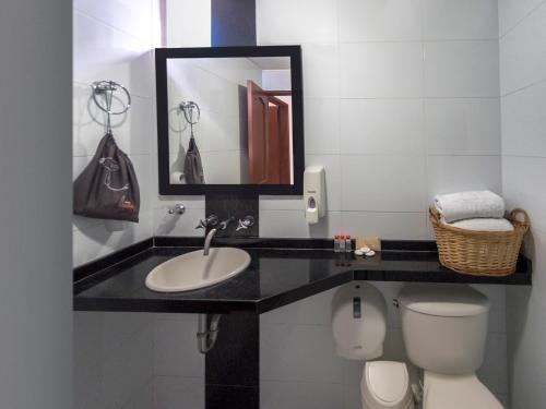 a bathroom with a sink and a toilet and a mirror at Hotel Buena Vista in Bucaramanga