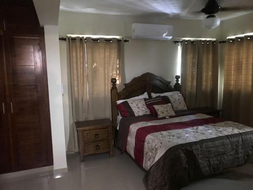 a bedroom with a bed and a dresser and curtains at Luxury Karla Apartments in Las Flores