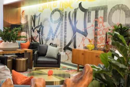 a living room with a wall covered in graffiti at Unscripted Durham, Part of JDV by Hyatt in Durham