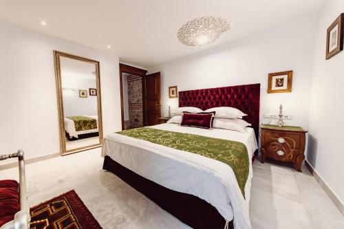 a bedroom with a large bed and a mirror at Villa Nepos Hotel in Split
