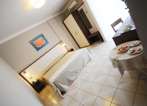 バルベリーノ・ディ・ヴァル・デルサにあるHotel Primaveraのベッドとテーブル付きの小さな部屋