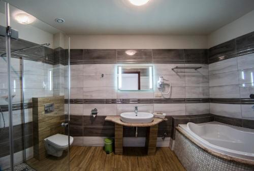 a bathroom with a sink and a tub and a toilet at Złote Arkady in Częstochowa